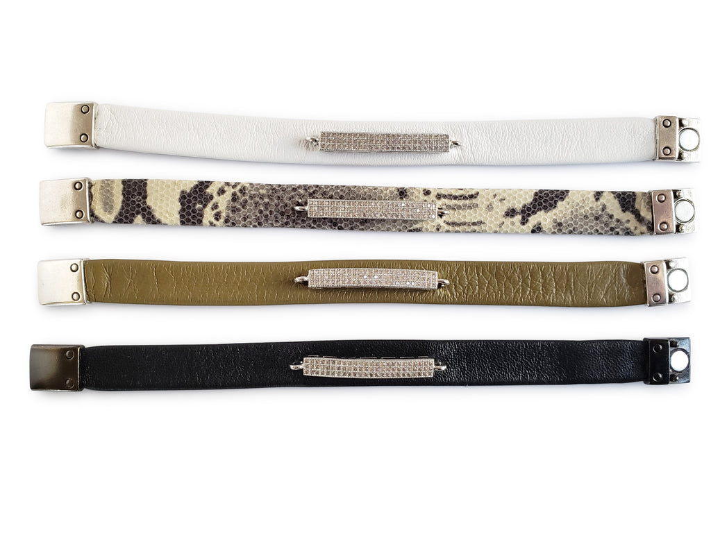 Open bracelets in white,python, olive and black leathers with silver micro pave sz bars.